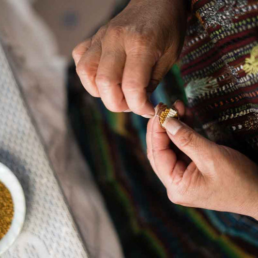 Artisan weaving beaded earrings at fair trade co-op in Guatemala.