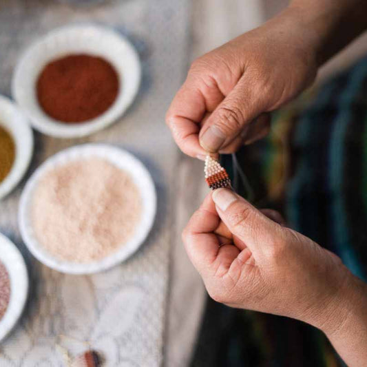 Artisan weaving a beaded earring at a women's fair trade co-op in Guatemala.