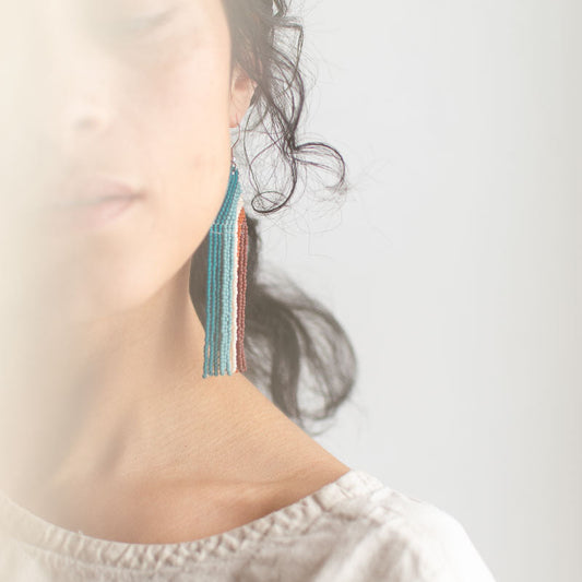 Close-up of a woman wearing colorful earrings with a blurred background