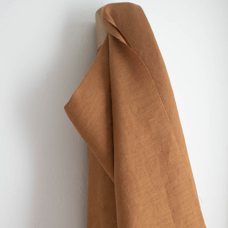 Brown fabric draped over a white wall