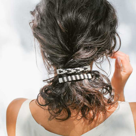 Back of woman's head wearing two beaded barrettes.