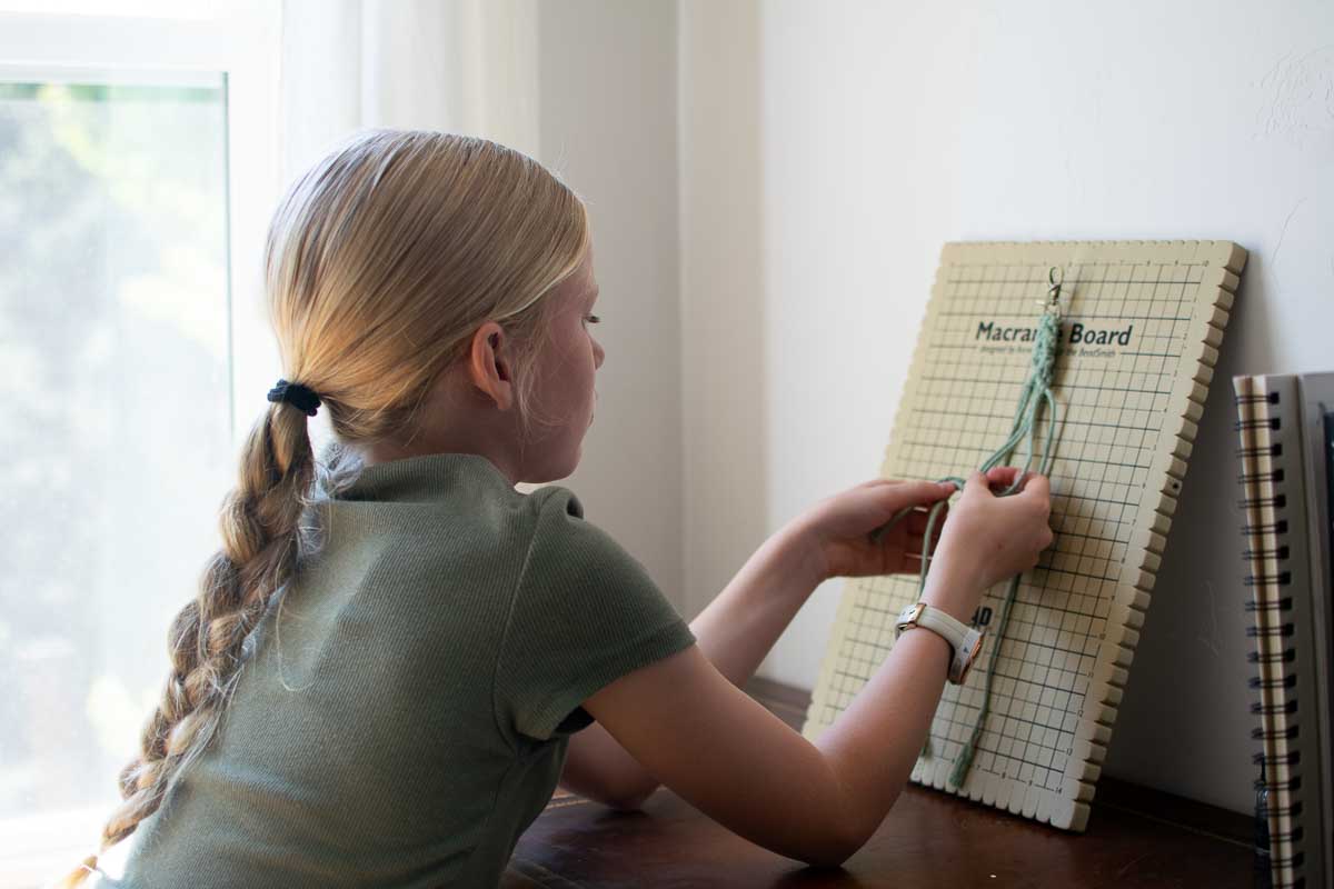 Lucia Catherine macraméing a keychain