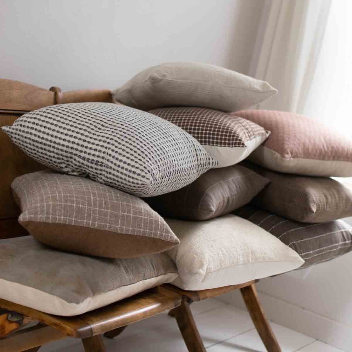 Group of pillows stacked on top of each other on a bench