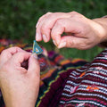 artisan weaving beaded earrings at a fair trade coop