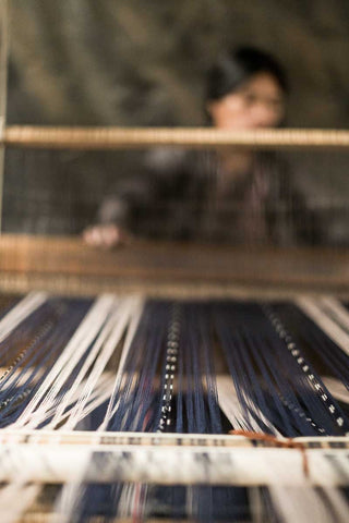 artisan using pedal loom to weave