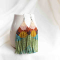 Beaded earrings that look like a sunrise with beige, pink, orange, yellow, purple, green, and turquoise blue seed beads.