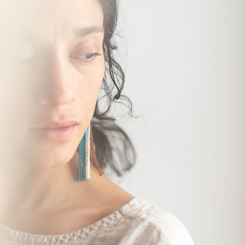 Woman wearing large earrings with a blurred background