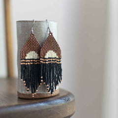 Beaded earrings woven with a semi circle in beige and brown with black and rose gold fringe.