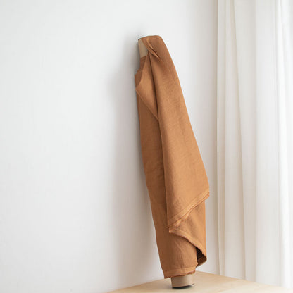 Brown linen fabric  against a white wall 