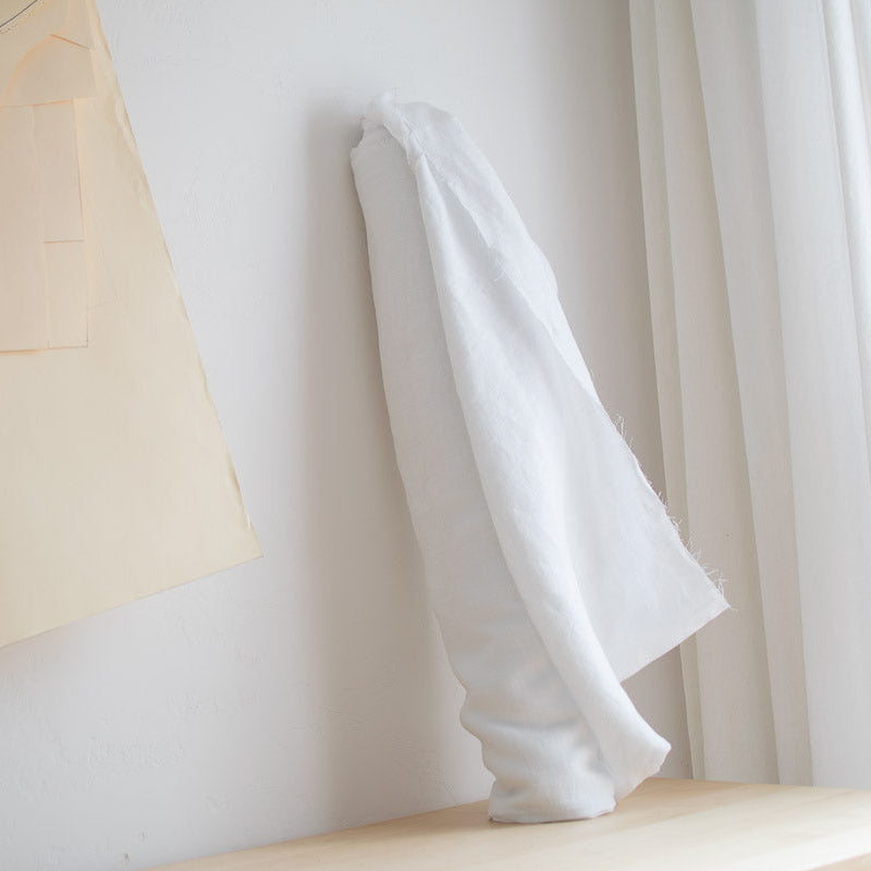 White linen on roll against a white wall with light curtains.