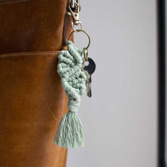 Macrame keychain clipped to a leather purse.
