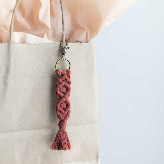 Macrame keychain hanging from a gift bag.