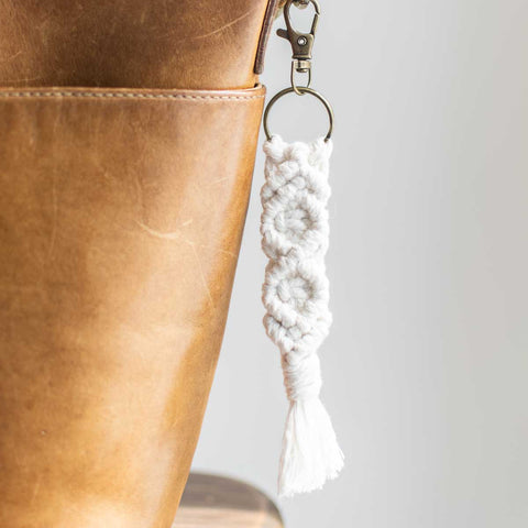 Natural macrame keychain clipped on leather purse.