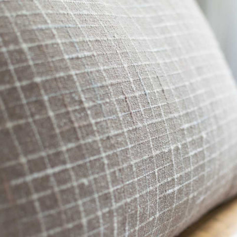 Textured gray pillow on a wooden chair with a blurred background