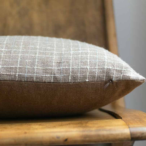 Textured cushion on a wooden chair against a neutral background