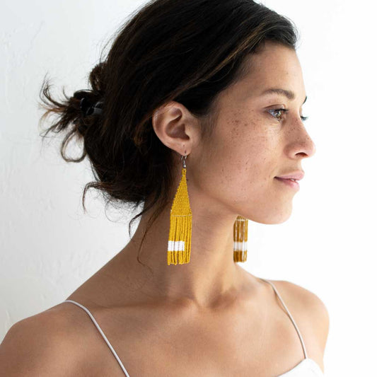 Beaded fringe earrings woven with yellow seed modeled on a woman.