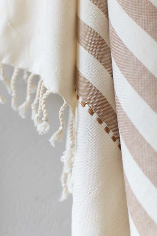 handwoven tan striped textile with fringe
