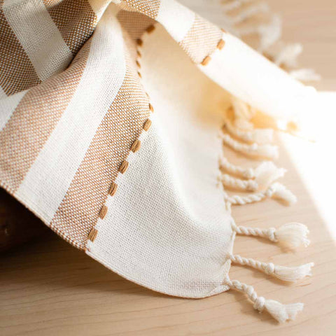 twisted fringe and subtle detail on tan striped woven towel