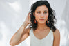woman wearing minimalistic beaded earrings