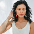 woman wearing minimalistic beaded earrings