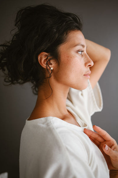 woman wearing minimalistic earrings