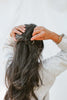 woman putting in matte brass hair pin