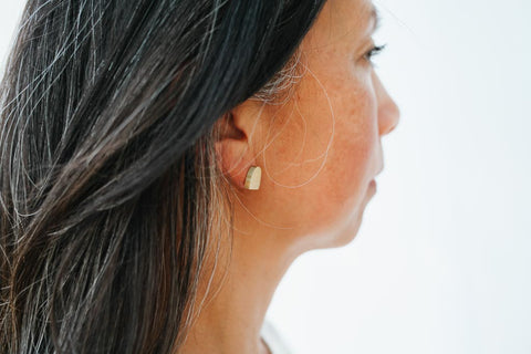 woman wearing matte brass fair trade earrings