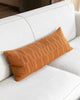 long lumbar pillow on couch - burnt orange with striped textures